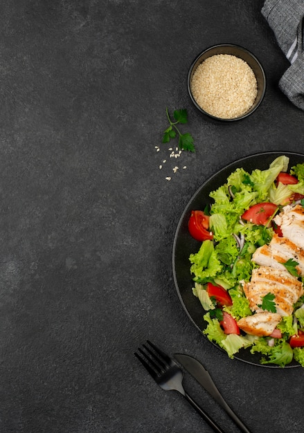 Flat lay salad with chicken and sesame seeds with copy-space