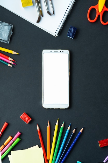 Flat lay of school supplies displayed with phone