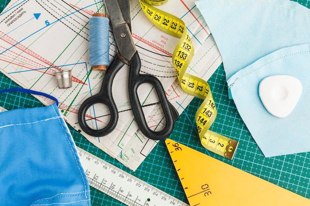 Flat lay of scissors with measuring tape and thread