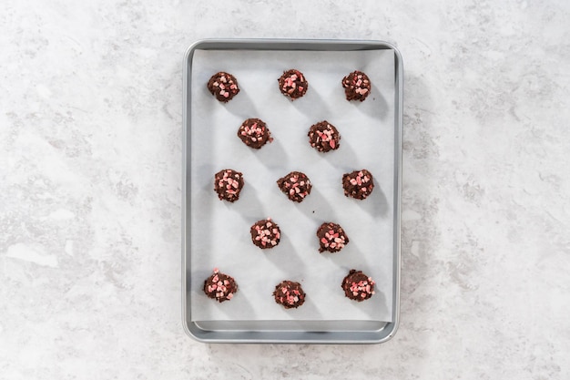 Flat lay. Scooping chocolate cookie dough with dough scoop to bake chocolate cookies with peppermint chips.