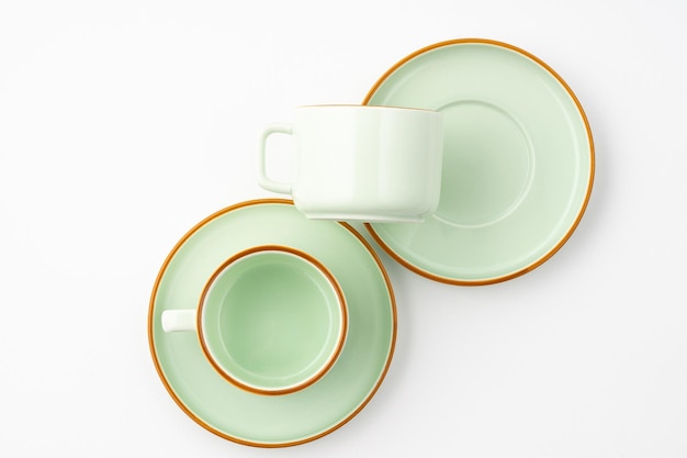 Плоская планировка набора керамической кухонной утвари, такой как чашки и тарелки на белом фоне