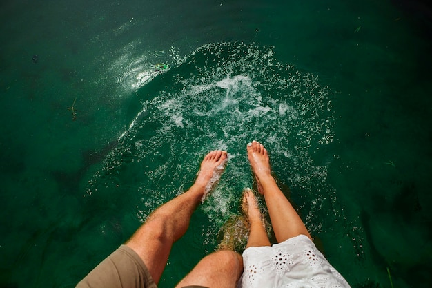 Flat lay shot of couple playing in the water with their feet