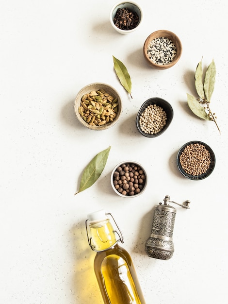 Flat lay of small bowls various dry spices and olive oil in glass bottle