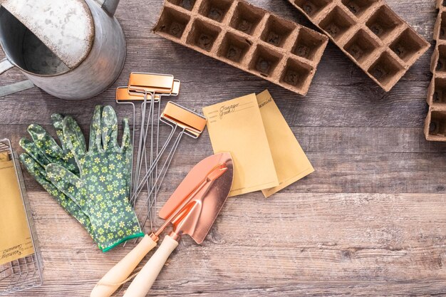 Flat lay. Small garden tools are ready for Spring planting season. Included garden gloves, shovel, watering can and plant tags.