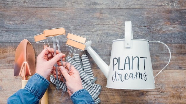 Flat lay. Small garden tools are ready for Spring planting season. Included garden gloves, shovel, watering can and plant tags.