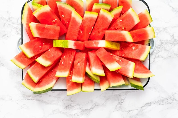 Flat lay. Small slices of red seedless watermelon on the tray for the party.