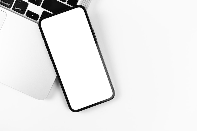 Mockup di smartphone piatto, desktop da ufficio con laptop, sfondo luminoso. vista dall'alto, copia la foto dello spazio