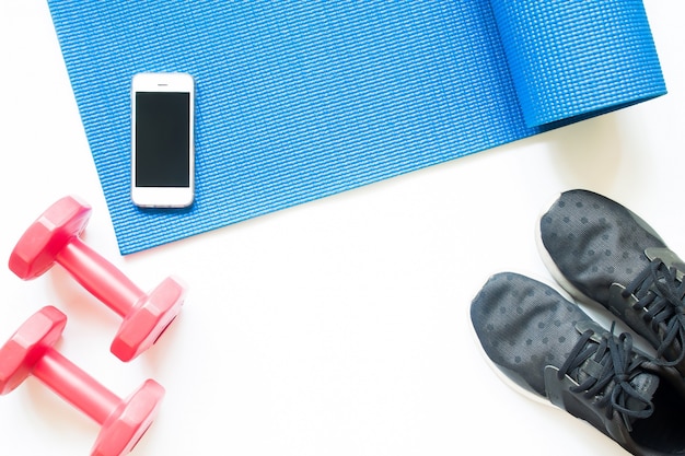 Flat lay of sport equipments with smartphone on white background