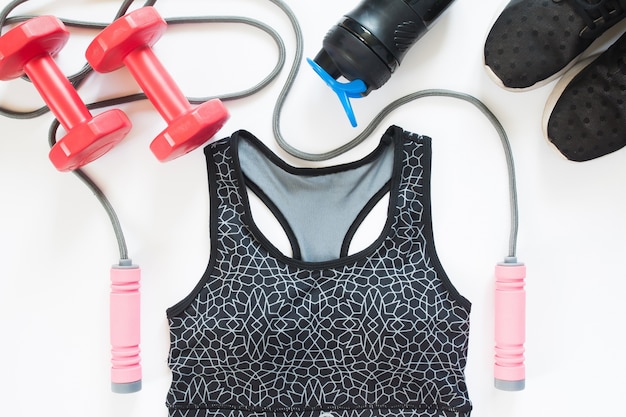 Flat lay of sport equipments with sport bra on white background, Overhead view, Top view