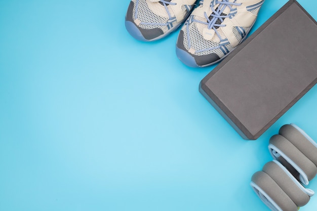 Flat lay of sport and fitness equipment on blue   with copy space.