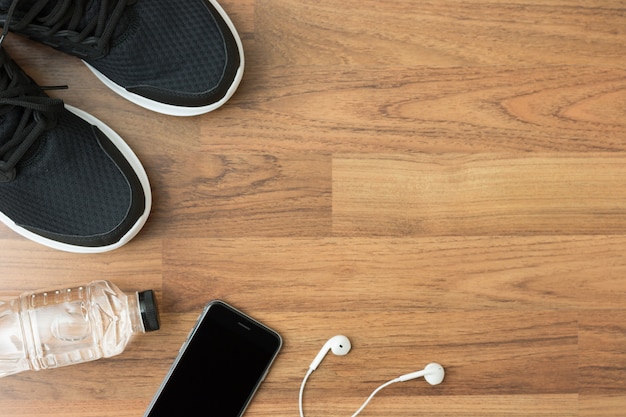 Flat lay of sports activities objects on wooden background with copy space