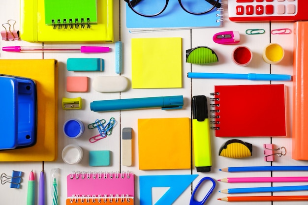 Flat lay of stationery on white wooden table background