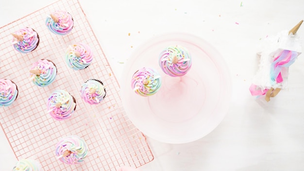 Flat lay. Step by step. Baking unicorn chocolate cupcakes with rainbow color buttercream frosting.