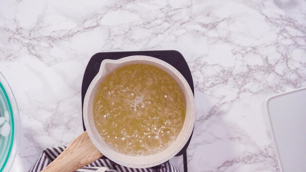 Flat lay. Step by step. Caramelizing sugar in a small cooking pot over the small electric stove.