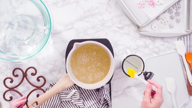 Flat lay. Step by step. Caramelizing sugar in a small cooking pot over the small electric stove.