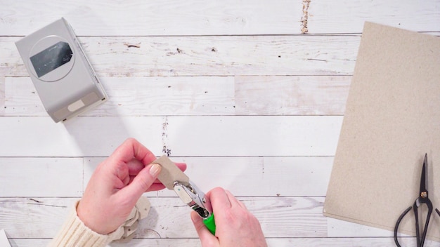 Flat lay. Step by step. Cutting out gift tags from brown paper with a paper punch.