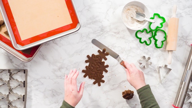 Photo flat lay. step by step. cutting out shapes with christmas cookies cutter from gingerbread cookie dough.