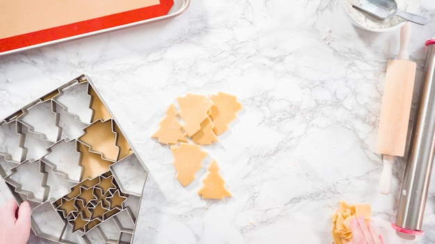 Flat lay. Step by step. Cutting out shapes with Christmas cookies cutter from sugar cookie dough.