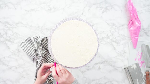 Flat lay. Step by step. Decorating round funfetti cake with pink and white fondant snowflakes.