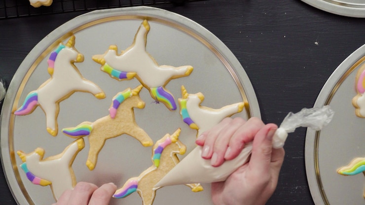 Photo flat lay. step by step. decorating unicorn sugar cookies with royal icing.