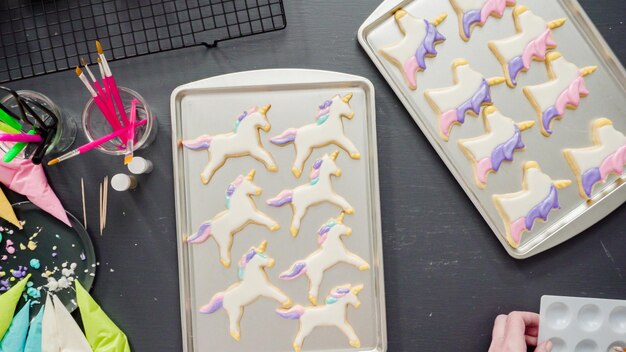 Flat lay. Step by step. Decorating unicorn sugar cookies with royal icing.