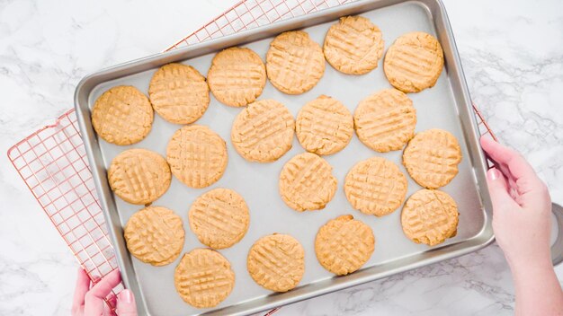 Flat lay. Step by step. Freshly baked peanut butter cookies on baking sheet.