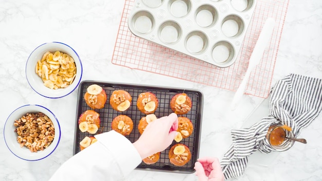 Flat lay. Step by step. Garnishing banana bread muffins with homemade caramel, banana chips,  and walnuts.