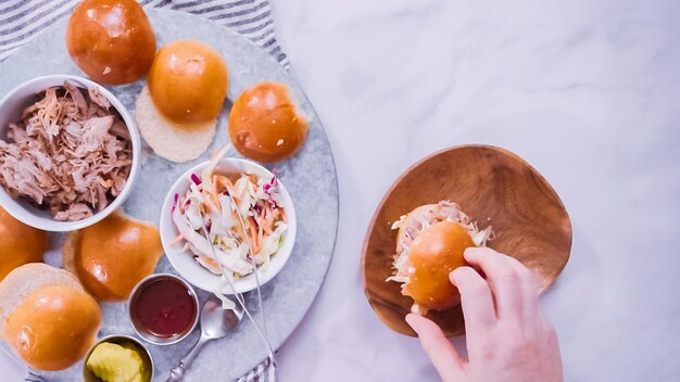 Flat lay. Step by step. Making pulled pork sandwiches with coleslaw on brioche buns.