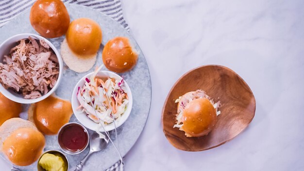 flat lay. step by step. making pulled pork sandwiches with coleslaw on brioche buns.