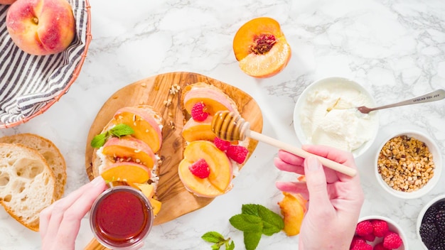 Flat lay. Step by step. Making ricotta toasts with organic peaches and berries.