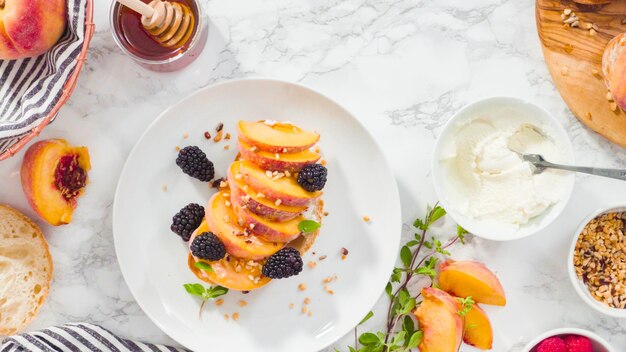 Flat lay. Step by step. Making ricotta toasts with organic peaches and berries.