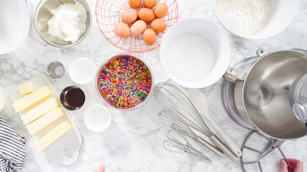 Flat lay. Step by step. Mixing ingredients in standing kitchen mixer to bake funfetti cake.