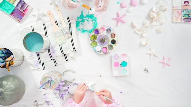 Flat lay. Step by step. Painting craft pumpkin with acrylic paint to create decorated mermaid Halloween pumpkin.