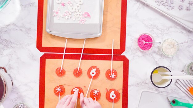 Flat lay. Step by step. Peeling cooled homemade lollipops from silicone baking mats.