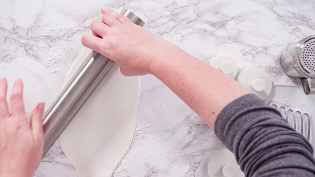 Flat lay. Step by step. Rolling our white fondant on a marble counter.