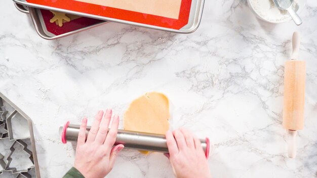 Flat lay. Step by step. Rolling out sugar cookie dough to bake Christmas cookies.