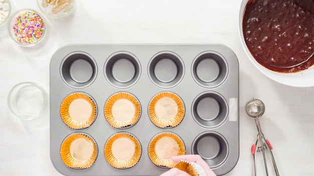 Photo flat lay. step by step. scooping batter with a cupcake scoop to make unicorn chocolate cupcakes with buttercream frosting.