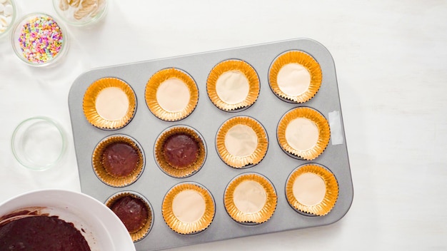 Flat lay. Step by step. Scooping batter with a cupcake scoop to make unicorn chocolate cupcakes with buttercream frosting.