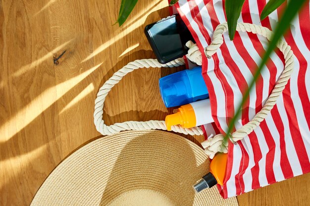 Flat lay summer beach bag background copy space on wooden table travel concept Free space for text Top view with copy spacexA