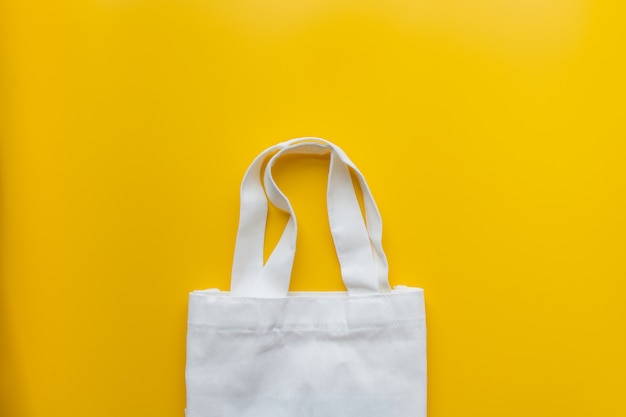 Flat lay of sustainable products cloth bag on yellow