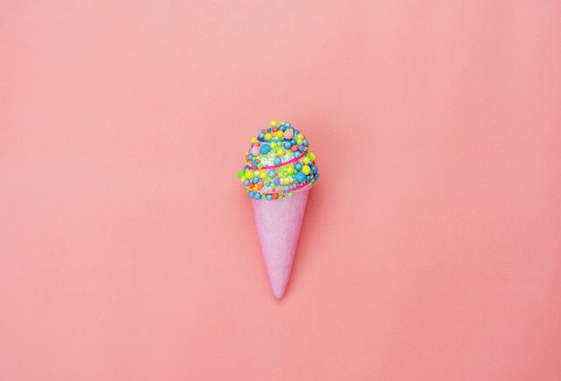 Flat lay of sweet ice cream cone on the modern rustic pink paper