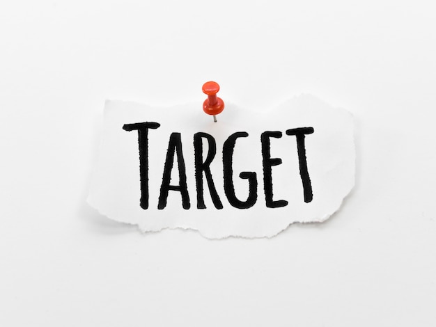 Photo flat lay of target written on piece of paper with pin