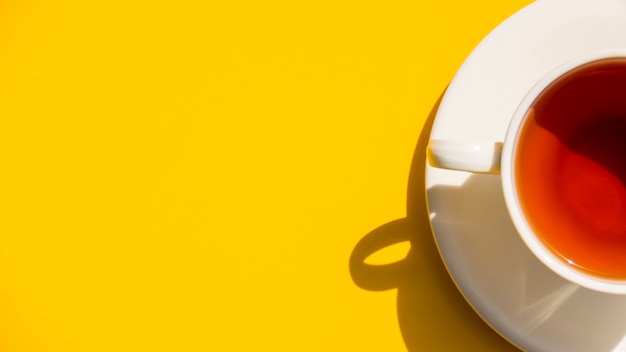 Flat lay tea cup on yellow background