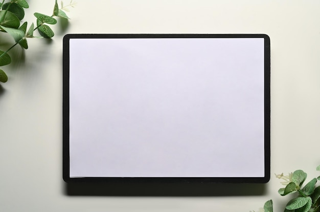Photo flat lay top view digital tablet and eucalyptus branches on white background blank screen for advertising text message