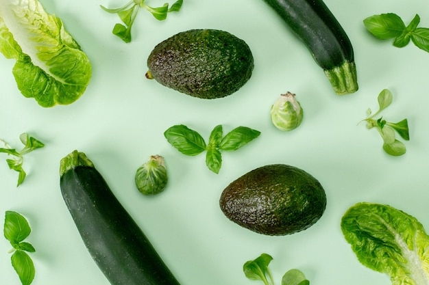 Flat lay top view green color vegetable isolated on a mint pastel background with a soft shadow