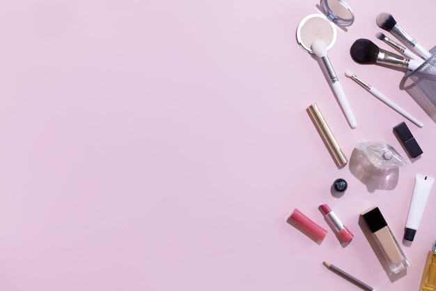 Flat lay and top view of make up products and cosmetics set on pink background with copyspace. Beauty concept for blogger, pastel women business office table desk