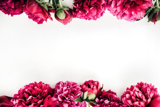 Flat lay, top view mock up floral composition with pink peony flowers on white surface