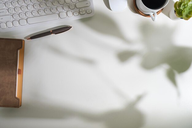 Photo flat lay top view office desk with diary keyboard coffee cup and potted plant copy space for your text