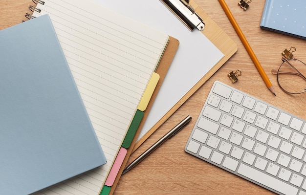 Flat lay top view office table desk Workspace with blank clip board keyboard office supplies pencils and pens