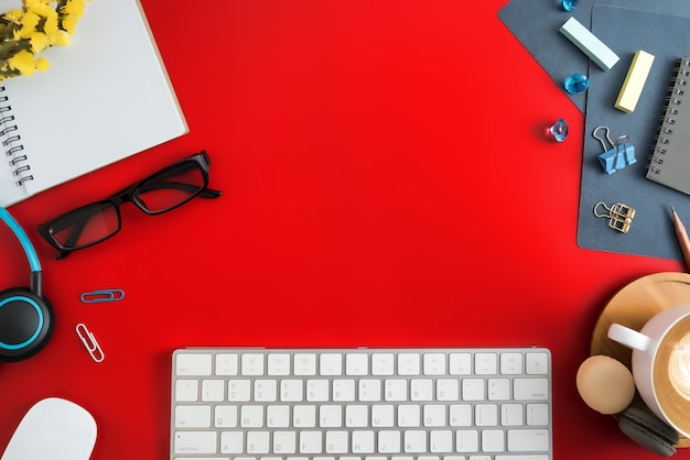 Flat lay, top view office workspace with blank note book, keyboard, office supplies.